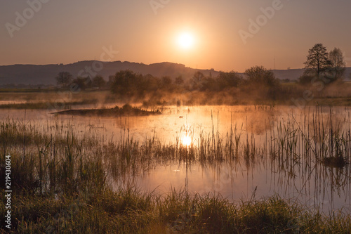 Misty Golden Sunrise Reflecting over Lake in Spring.