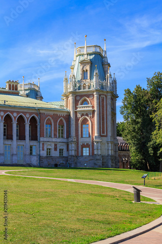Fragment of architectural ensemble of Great Palace in Museum-reserve Tsaritsyno in Moscow on a blue sky and green lawn background in sunny summer morning