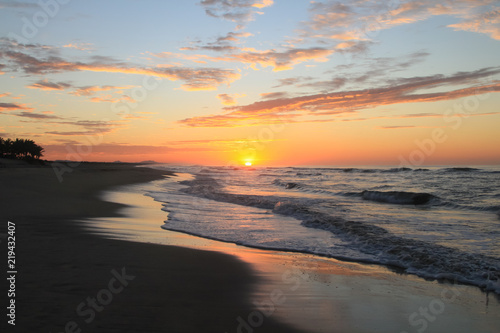 Dramatic Tropical Sunrise over Pacific Ocean and Sandy Beach.