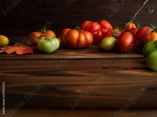 Beautiful tomatoes on dark wood background, copy space