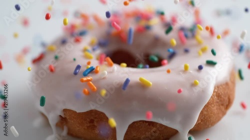 Sprinkling candy chocolate on frosted doughnut. Shot with high speed camera, phantom flex 4K. Slow Motion.