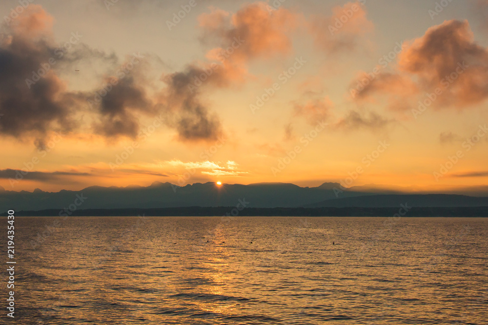 Golden Sunrise behind Alps Mountains and over Lake Leman.