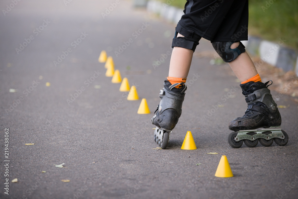 Closeup of kid boy's roller skaters doing twists on asphalt Closeup of kid boy's roller skaters doing twists on asphalt