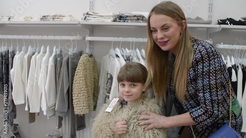 Mom and daughter while shopping in a clothing store photo