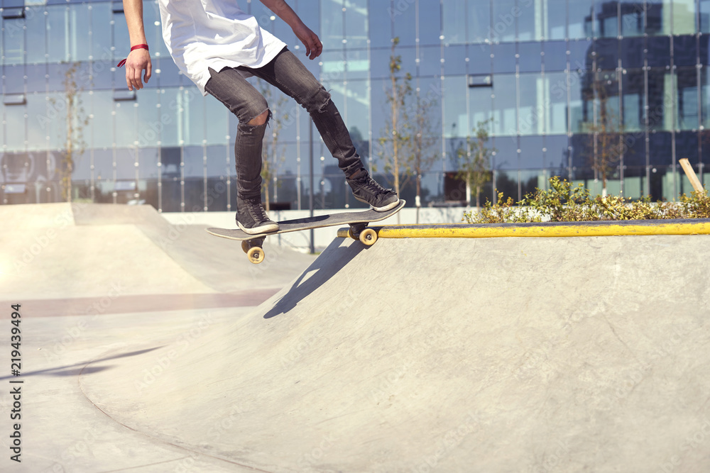 Skateboarder doing a trick in a skate park, practice freestyle extreme sport Skateboarder doing a trick in a skate park, practice freestyle extreme sport
