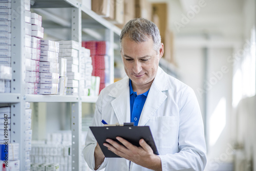 Obraz na plátně Portrait of mature male pharmacists working in modern drugstore