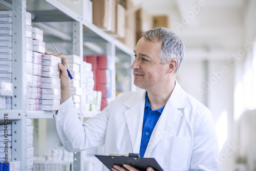 Portrait of mature male pharmacists working in modern drugstore