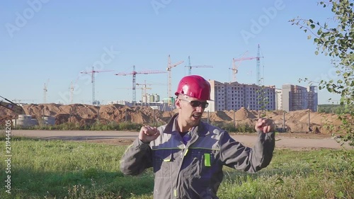 Dancing young engineer with helmet after work on the construction site. photo