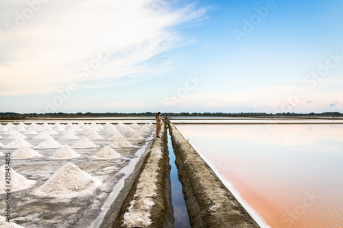 Salt farm with beautiful reflection of nature at sunset time in Na Klua - baan laem, Petchaburi,Thailand. Salt production is made from sea water and sunlight until dry into crystal.