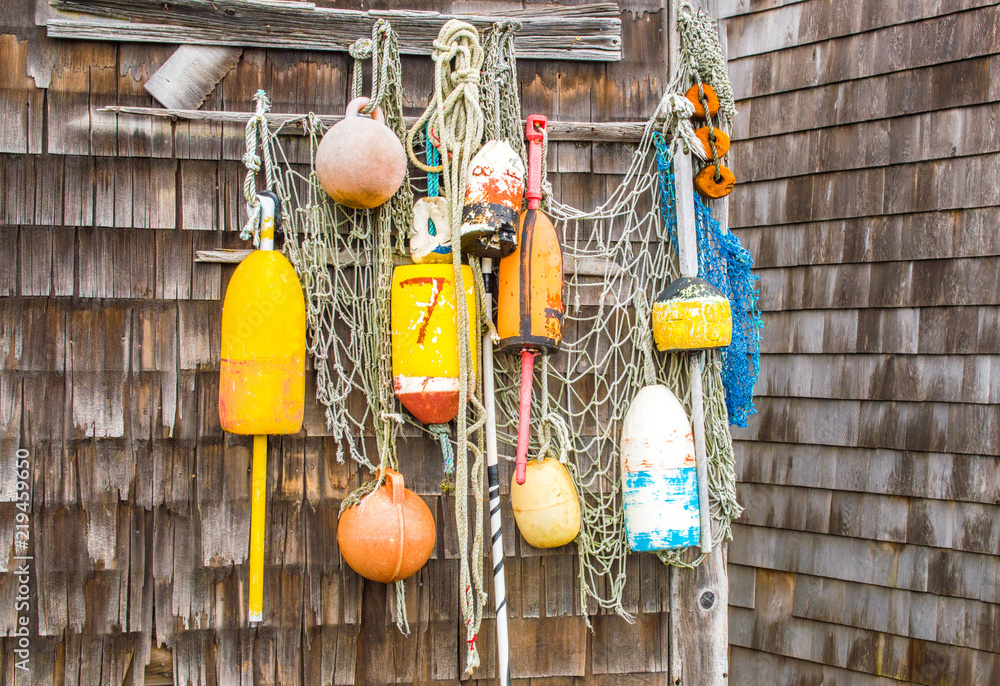 colorful lobster buoys and rope netting hanging on the wall of a