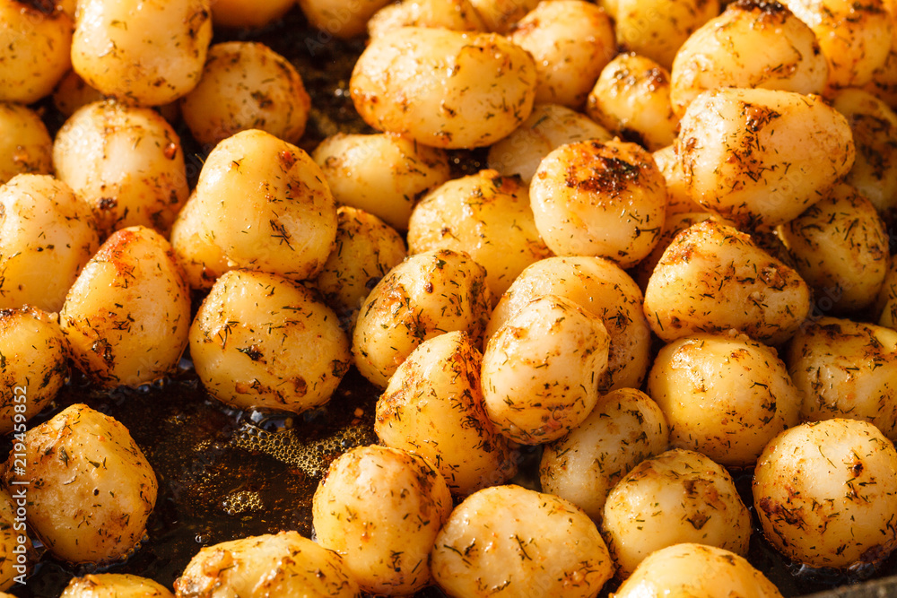 Backed young potatoes with spices in bowl Backed young potatoes with spices in bowl
