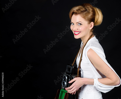 Smiling girl in white dress with retro old photo camera. Vintage photography concept - woman in retro style with vintage photo camera. Happy woman with retro camera. Photographer with vintage camera. © Svitlana