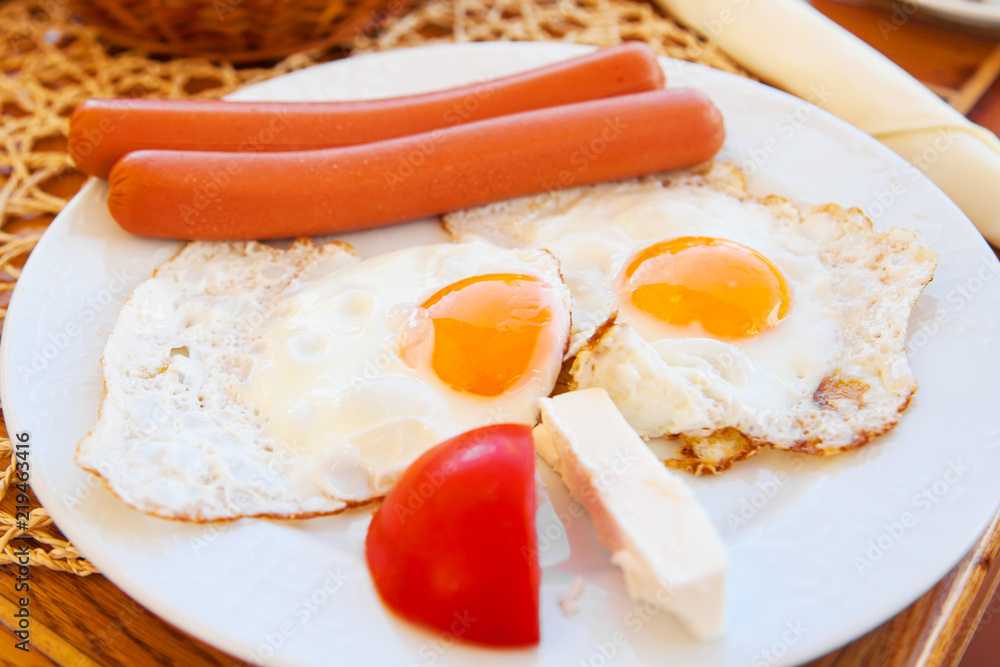 Fototapeta premium Traditional breakfast with fried eggs and sausages