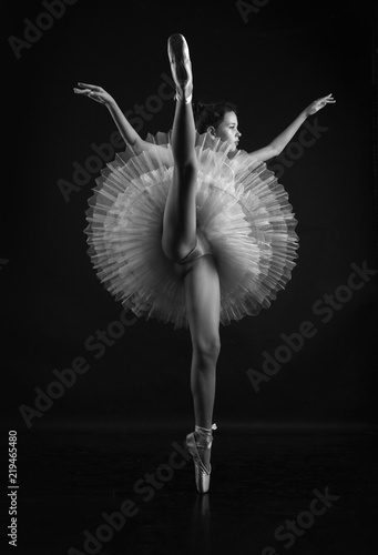 A young ballerina in a ballet tutu and on pointe. Black and white photo.