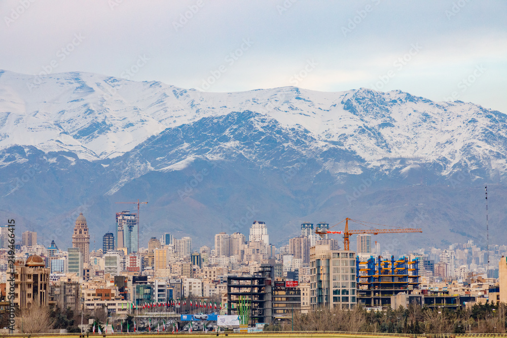 Fototapeta premium Islamic Republic of Iran. Tehran city center and mountainous background. Freeway with flags. 02 March 2018