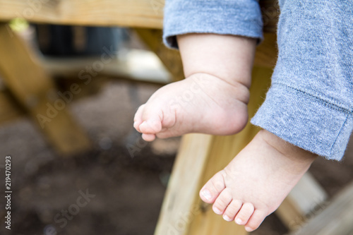 A baby's two feet with a picnic table as background