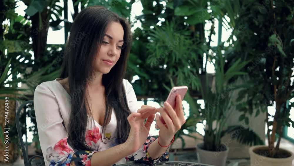 custom made wallpaper toronto digitalYoung brunette woman in summer cafe web surfing with her pink smartphone. Left to right pan slow motion medium shot