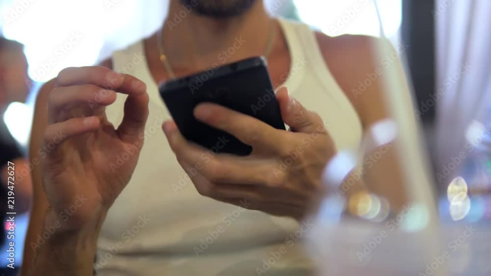 Adult man with mobile phone at city summer cafe close-up Adult man with mobile phone at city summer cafe close-up