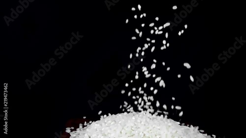 slow motion of falling rice on black background on the pile 240 photo