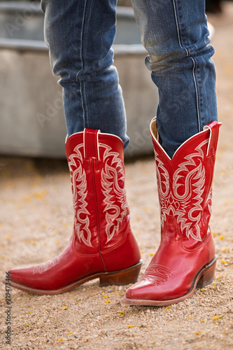 Female in red cowboy boots on gravel road