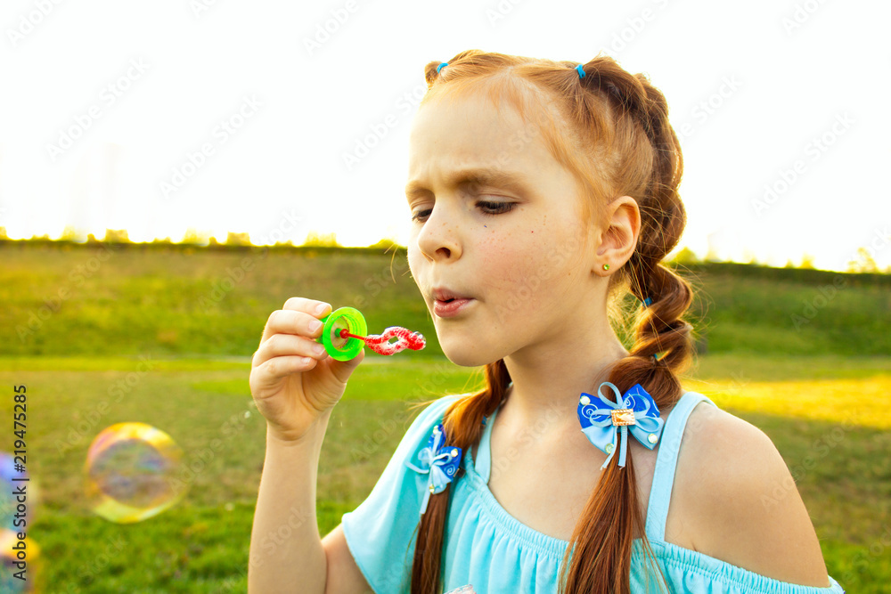 beautiful cute girl with red hair blowing bubbles beautiful cute girl with red hair blowing bubbles