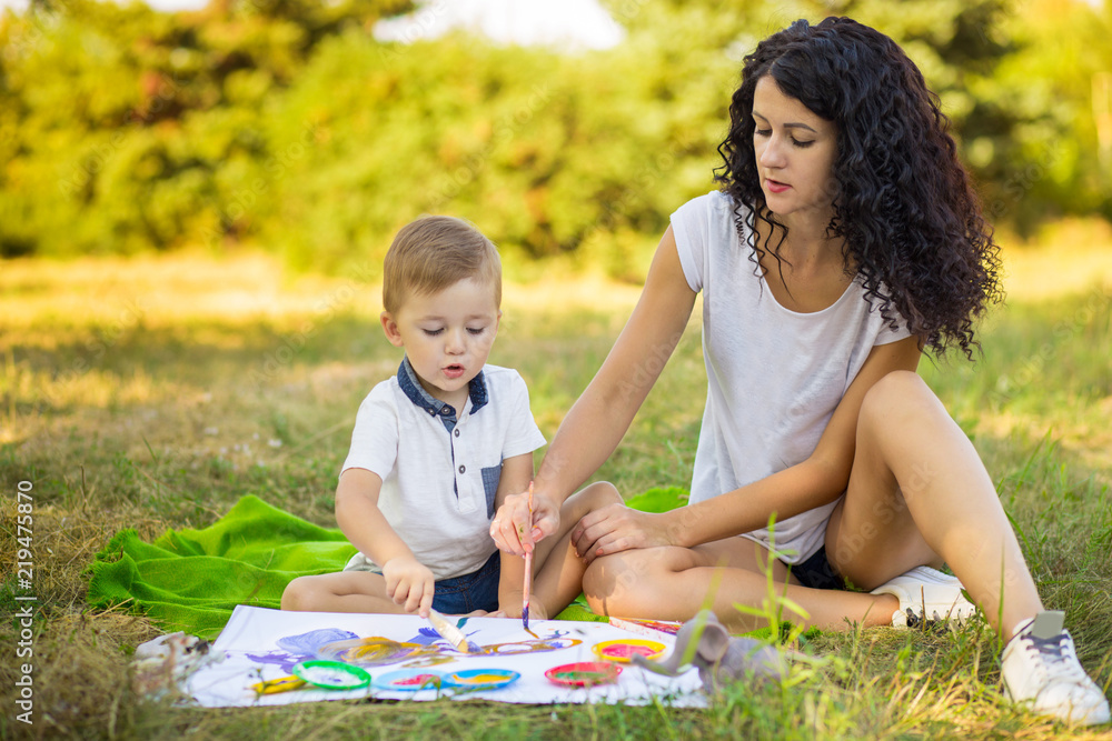 Fototapeta premium Mother and son draw outdoor. Concept of happy family