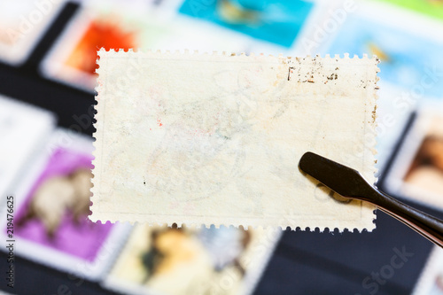 Fotografie tongs keeps postage stamp with bad glue back side