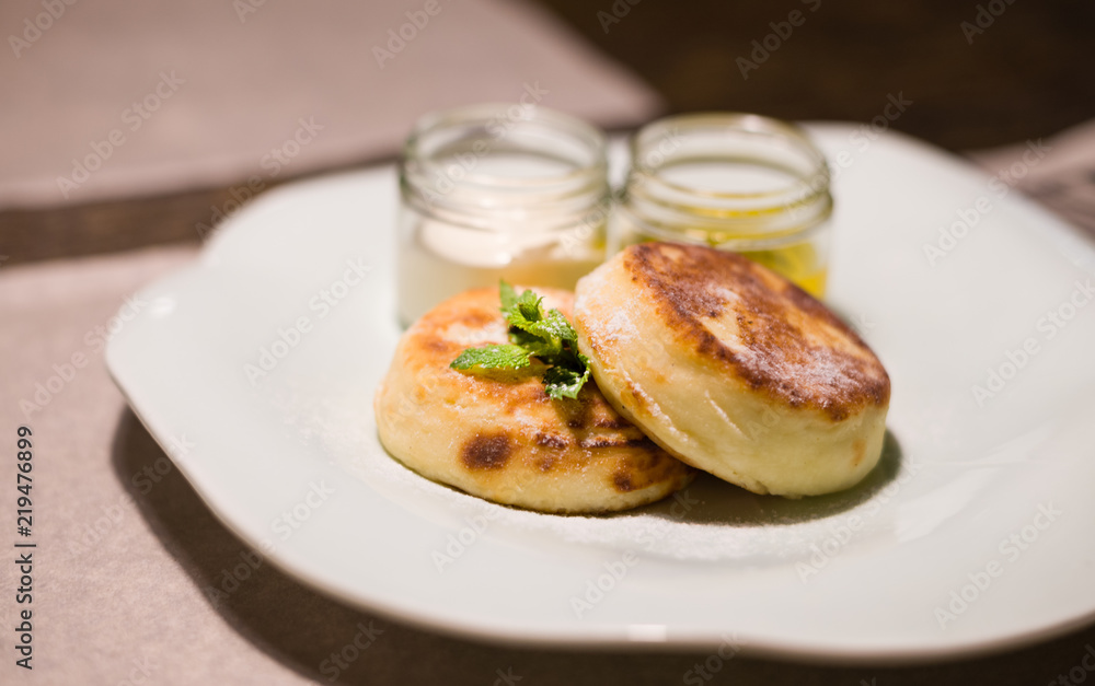 pancakes with honey and sour cream on a white plate (horizontally) pancakes with honey and sour cream on a white plate (horizontally)