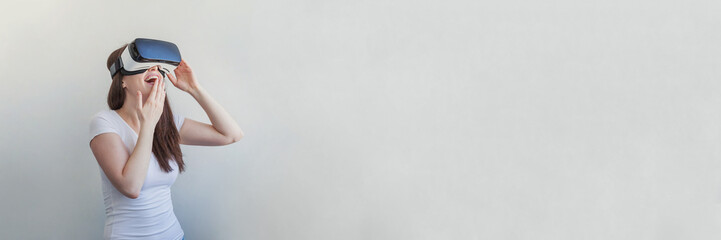 Smile young woman wearing using virtual reality VR glasses helmet headset on white background. Smartphone using with virtual reality goggles. Technology, simulation, hi-tech, videogame concept. Banner