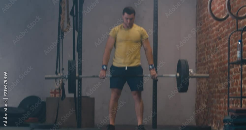 HANDHELD portrait of Caucasian male athlete working out with a barbell in a functional gym. 4K UHD HANDHELD portrait of Caucasian male athlete working out with a barbell in a functional gym. 4K UHD
