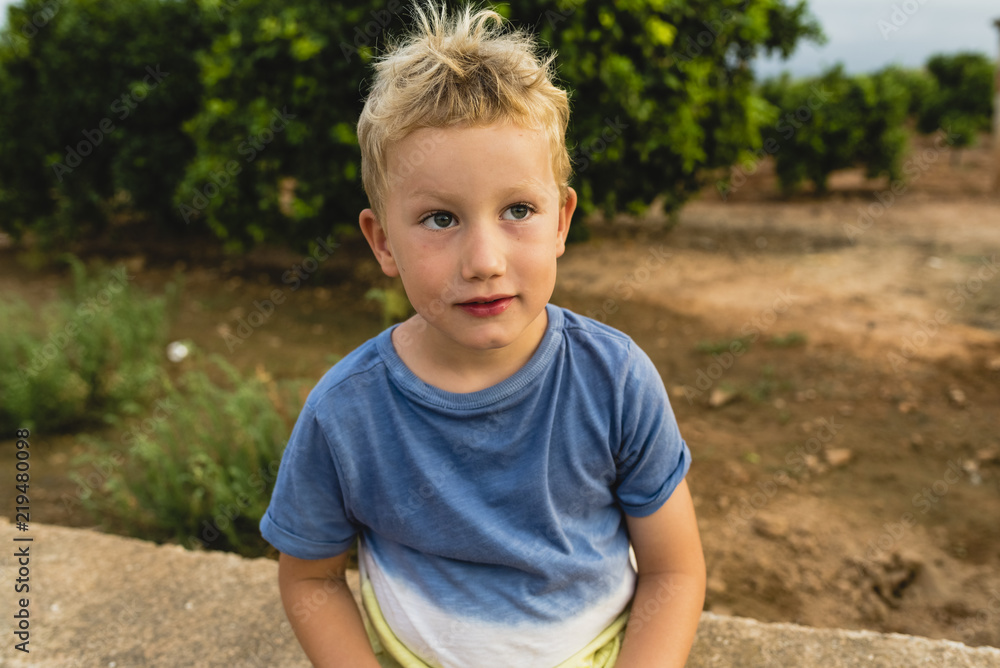 Blond boy making funny faces outdoors Blond boy making funny faces outdoors