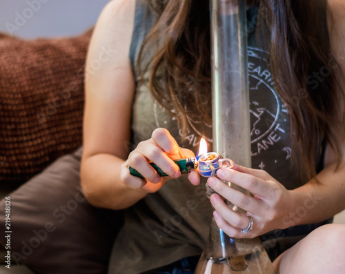 Slika na platnu A brunette burning/smoking marijuana out of bong