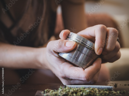 A female grinding up cannabis leaf photo