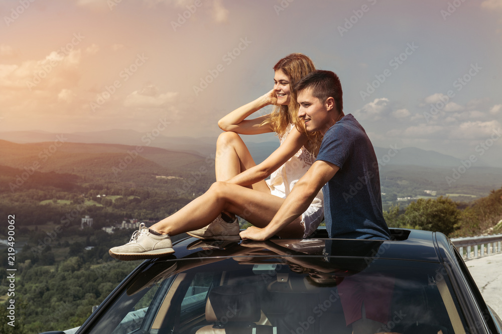 Young couple on road trip travel by car together and enjoy the nature view from the top