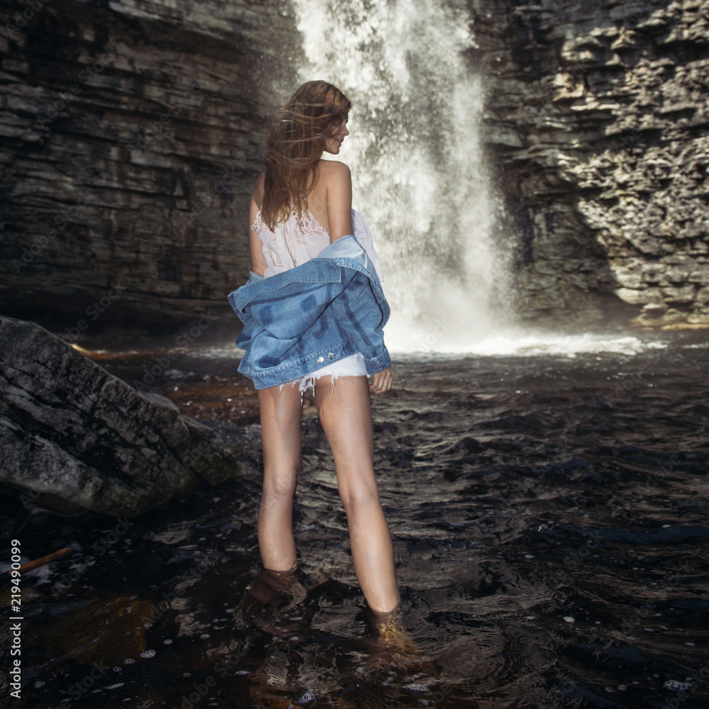 Beautiful model girl with long legs posing near a waterfall wearing jeans  jacket Stock Photo | Adobe Stock