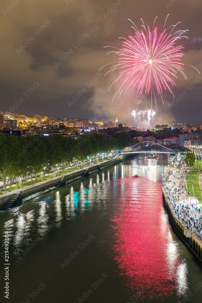 Landscape of the city of Bilbao, Spain at night. Fireworks from the annual city festivities.