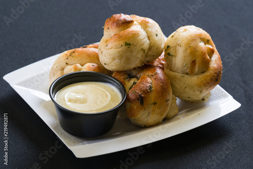 Close up shot of garlic knots with dipping sauce