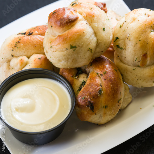 Close up shot of garlic knots with dipping sauce