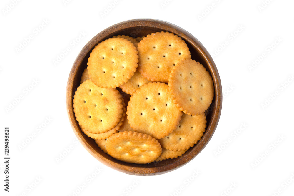 Round salted cracker cookies in wooden bowl isolated on white background.