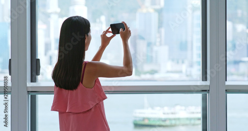 Woman taking photo out of window in Hong Kong © leungchopan