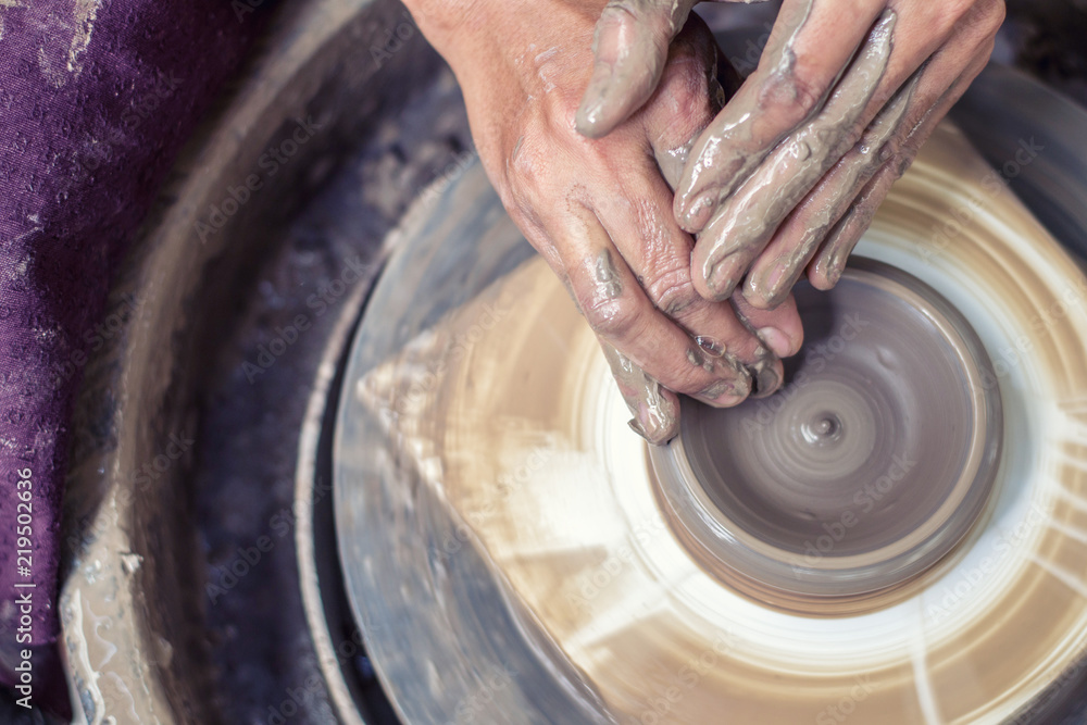 Fototapeta premium Hands working on pottery wheel