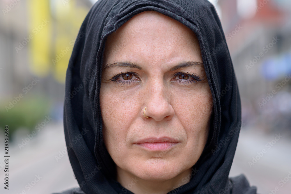 Pensive mature woman wearing a black head scarf Pensive mature woman wearing a black head scarf