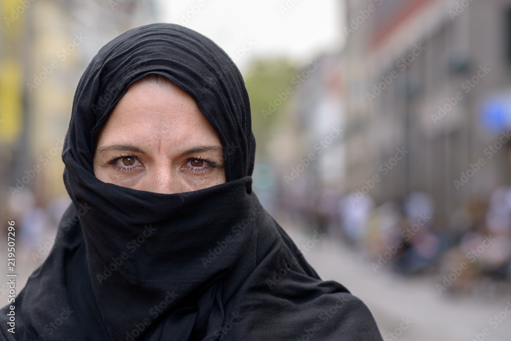 Muslim woman wearing a black hijab in town Muslim woman wearing a black hijab in town