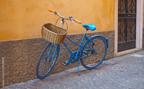 Isolated turquoise bike near the facade of the house