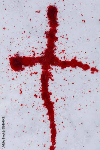 A cross made of red blood on a white snow in Finland.