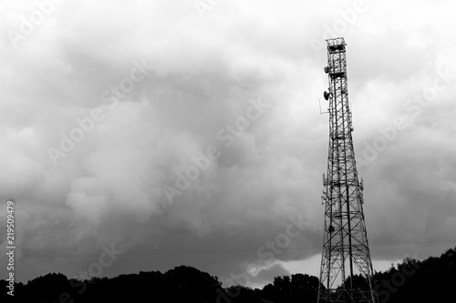 monochrome silhouetted telecommunications mast sited on farmland 
