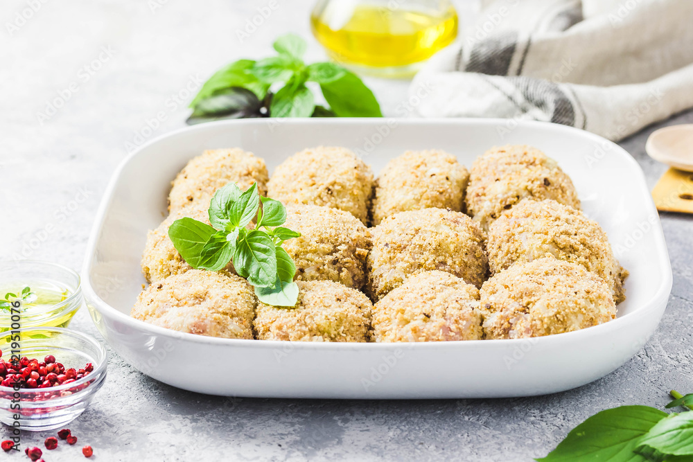 Healthy oven baked chicken rissoles on baking dish, ready for cooking. Selective focus, space for text. Healthy oven baked chicken rissoles on baking dish, ready for cooking. Selective focus, space for text.