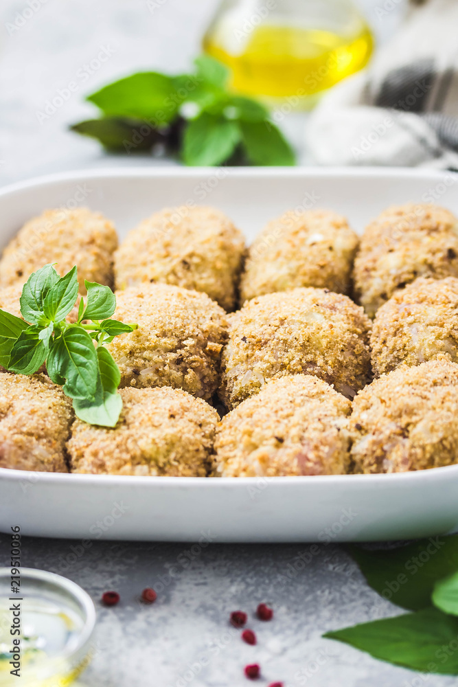 Healthy oven baked chicken rissoles on baking dish, ready for cooking. Selective focus, space for text. Healthy oven baked chicken rissoles on baking dish, ready for cooking. Selective focus, space for text.
