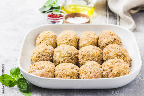 Photography Healthy oven baked chicken rissoles on baking dish, ready for cooking