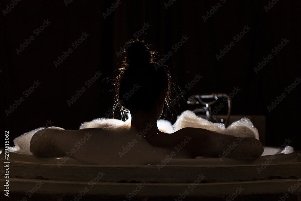 back of view woman take a bath in bathtub,Low key - obrazy, fototapety, plakaty 